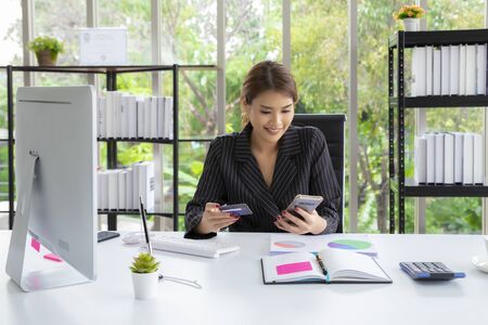 Woman using credit card to pay the bill. Technology online shopping.の写真素材