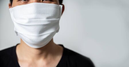 A man wear breathing medical respiratory mask against the Coronavirus (CoVID-19) isolated on white background.の写真素材