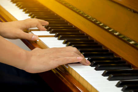 Man hands playing piano, close up.の写真素材