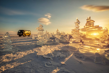 Sunset reflected in a large block of ice hummock on the frozen lake background.の写真素材