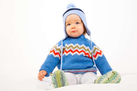 Young Kid is sitting in Studio with Winter Clothes and Hat.の写真素材