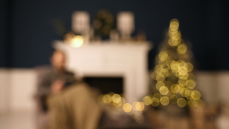 Man reading a book in living room on Christmas.の写真素材