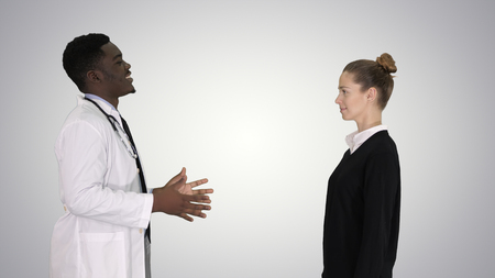 Doctor telling good news and patient leaves on gradient background.の写真素材