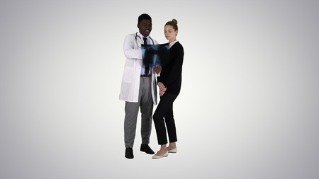 Doctor shows the patient chest x-ray on gradient background.の写真素材