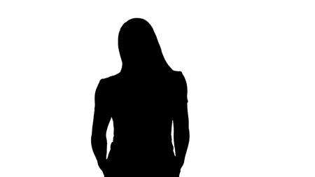 Silhouette Portrait of girl walking with hands in pockets of pink dress.の写真素材