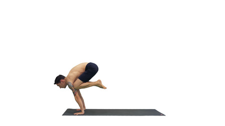 Handsome man doing yoga asanas on white background.