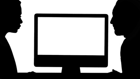 Back view to the monitor of the computer. Silhouette Business collegues a man and a woman having a talk about what is on the screen of the computer. Professional shot in 4K resolution. 007. You can use it e.g. in your commercial video, business, presentation, broadcastの写真素材