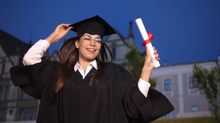 Happy graduating female student dancing.