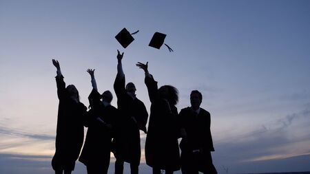 Silhouette of Graduating Students Throwing Caps In The Air.の写真素材