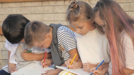 Four Kids Sitting and Painting outdoors.の写真素材