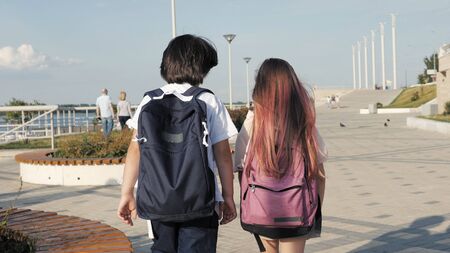 Two classmates walking with backpacks.の写真素材