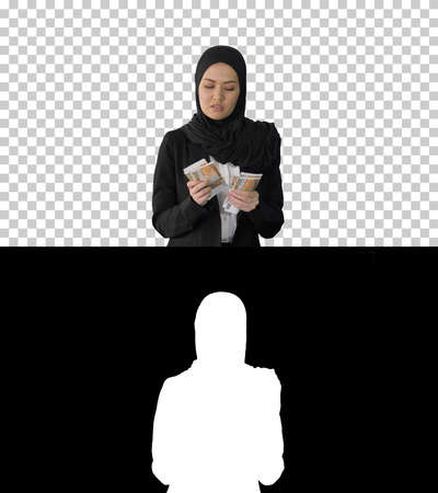 Pretty woman in hijab walking and counting money, Alpha Channelの写真素材