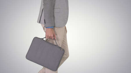 Man in casual walking with briefcase on gradient background.の写真素材