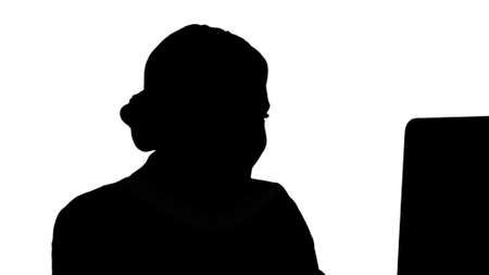 Silhouette Adult businesswoman looking at computer in office.の写真素材