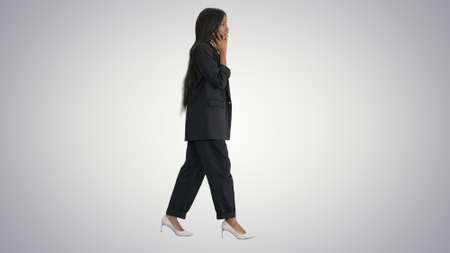 Casual African American Businesswoman talking on phone while walの写真素材