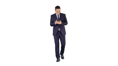 Businessman on the phone typing text message walking on white background.の写真素材