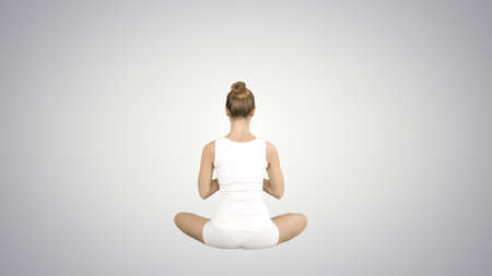 Beautiful young woman wearing sportswear practicing yoga sittingの写真素材