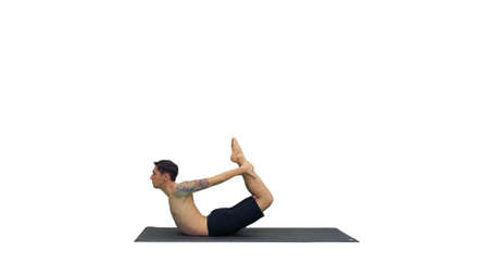 Sporty muscular young yogi man doing backbend exercise, dhanurasの写真素材
