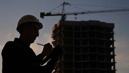 Engineer in a helmet writing check list.の写真素材