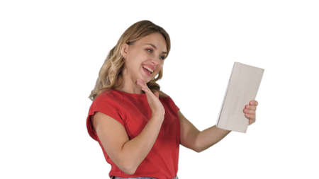 Blonde young girl with tablet in hand, making a video call or re