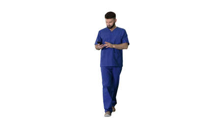 Surgeon doctor walking and using his phone on white background.の写真素材