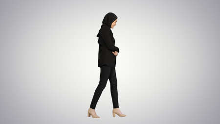 Smiling islamic female model wearing hijab walking and looking aの写真素材