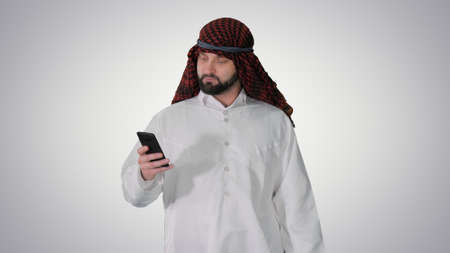 Arab man using his smartphone surfing on the internet or messagiの写真素材