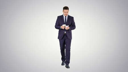 Man in suit walking and counting money on gradient background.の写真素材