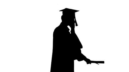 Silhouette Graduating student starts walking and making a call.の写真素材