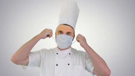 Male chef cook taking medical mask off and smiling to camera onの写真素材