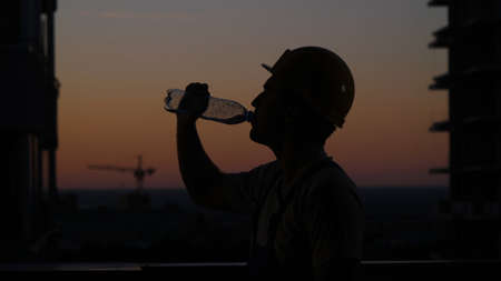 Construction Man Drink Water in a Hot Summer Day.の写真素材