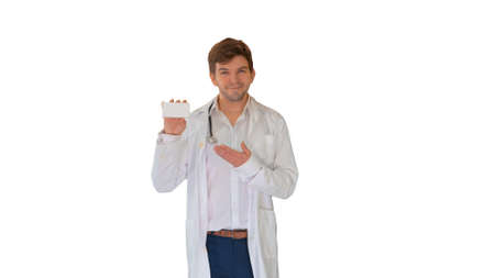 Smiling male doctor with stethoscope walking and advertising pil