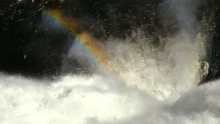 Rainbow over the running water of the waterfall.の写真素材