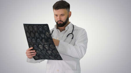 Confident doctor working with MRI scan results on gradient backg