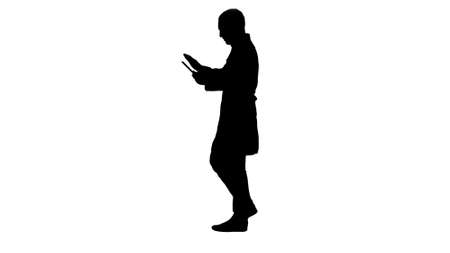 Silhouette Doctor using tab while walking.の写真素材