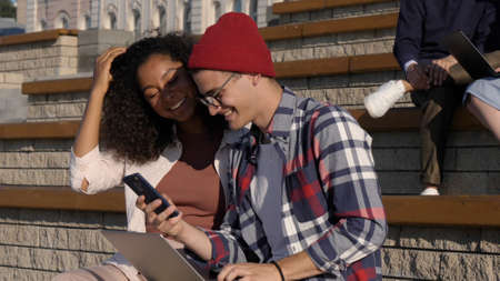 Millennial man and woman explore social media together using smaの写真素材
