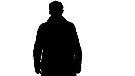 Silhouette Fashionable man with dark beard in trench coat walkinの写真素材