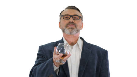 Mature man in a suit drinking whiskey or cognac on white backgroの写真素材