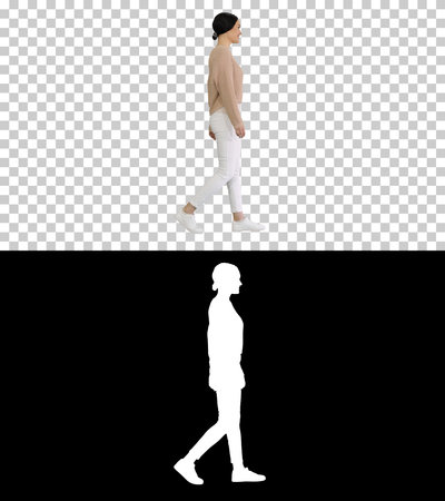 Relaxed young woman walking towards and looking with smile at caの写真素材