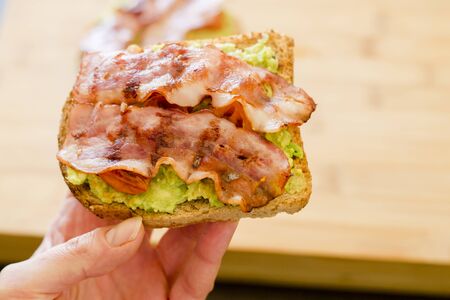 avocado toast with cherries tomatoes and baconの写真素材