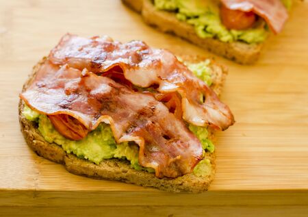 avocado toast with cherries tomatoes and baconの写真素材