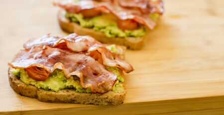 avocado toast with cherries tomatoes and baconの写真素材