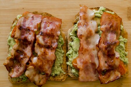 avocado toast with cherries tomatoes and baconの写真素材