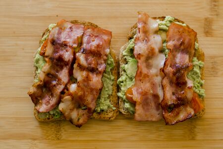 avocado toast with cherries tomatoes and baconの写真素材