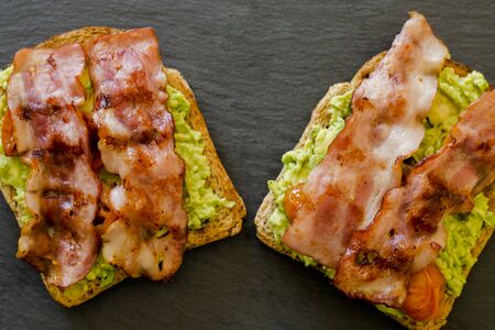 avocado toast with cherries tomatoes and baconの写真素材