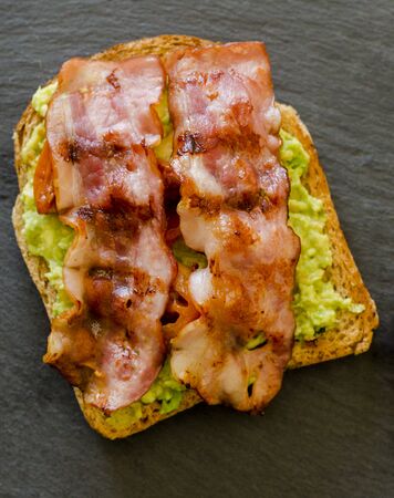 avocado toast with cherries tomatoes and baconの写真素材