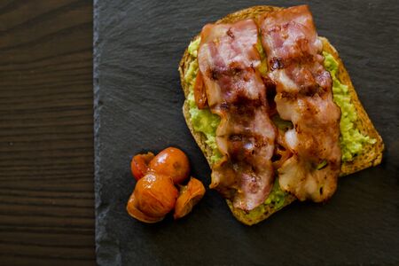 avocado toast with cherries tomatoes and baconの写真素材