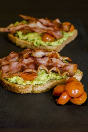 avocado toast with cherries tomatoes and baconの写真素材