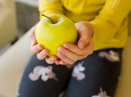 little girl hold green appleの写真素材