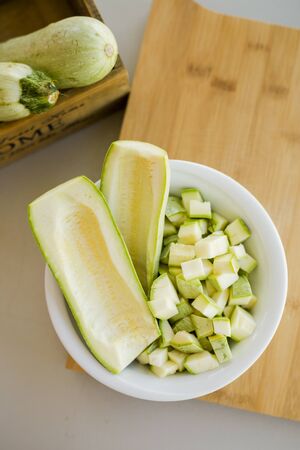 Bowl with cutted zuchini on stone slate on kitchen table, close-upの写真素材